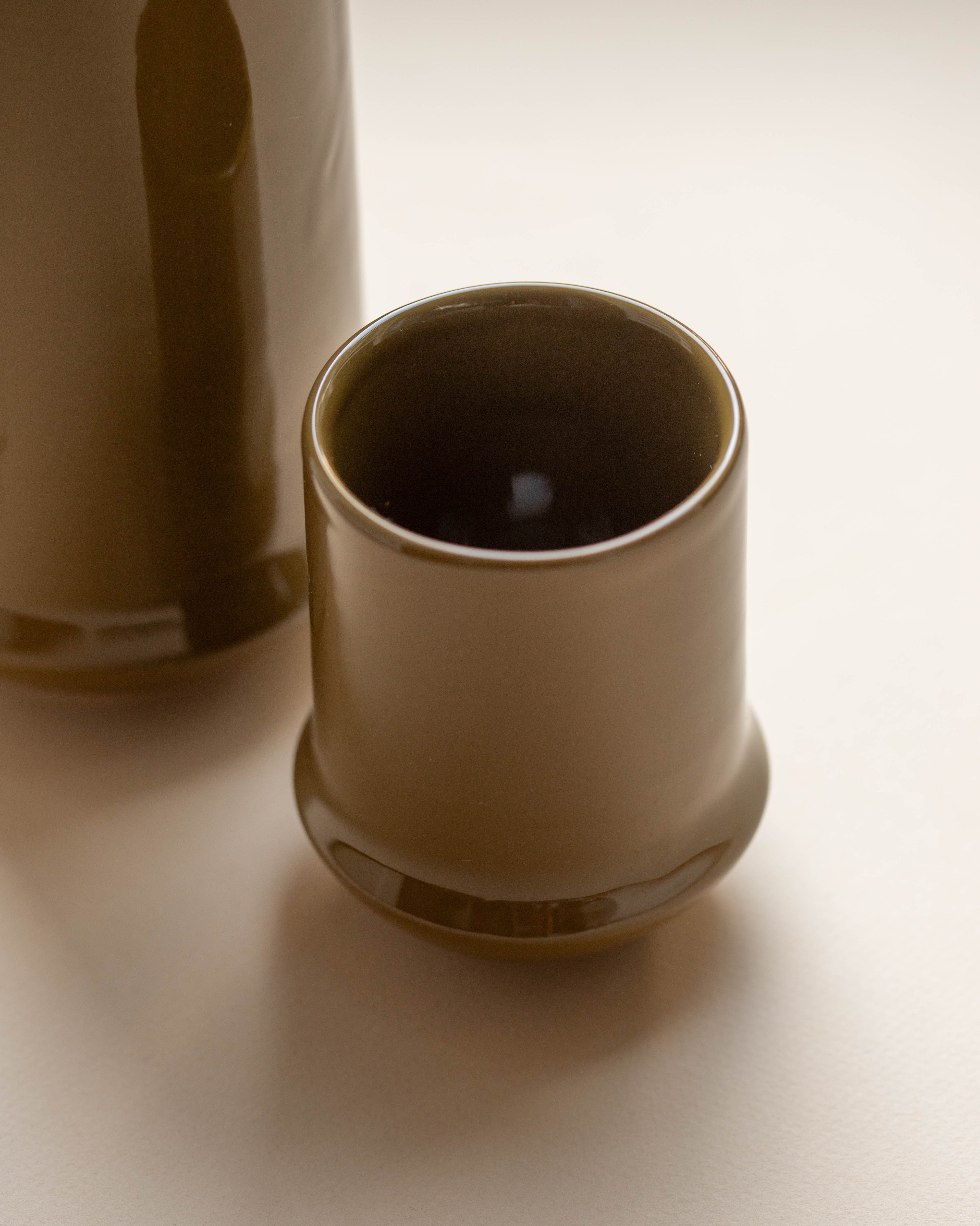 Ceramic cup and pitcher on a light background